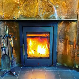 a stone fireplace with a fire in it at The Granby Inn in Longframlington
