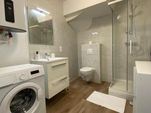 a white bathroom with a washing machine in it at Cocon Citron in Bergerac