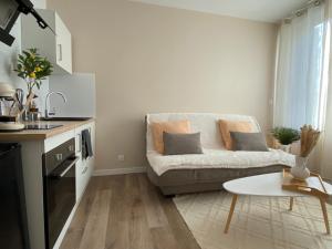 a living room with a couch and a table at Cocon Citron in Bergerac
