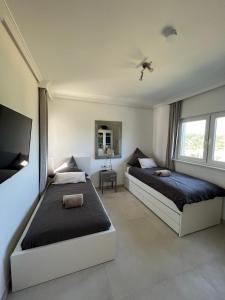 a bedroom with two beds and a flat screen tv at Moderne Villa mit Pool in Sant Josep de Sa Talaia