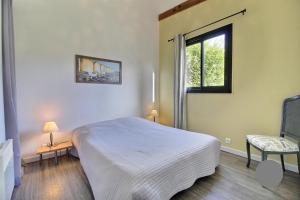 a bedroom with a white bed and a window at Ty Glaz et ty Perenn, les gîtes de Rhuys in Sarzeau