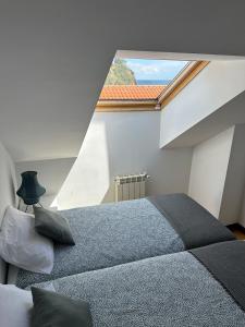 a bedroom with a large bed and a large window at Alojamiento Epìco in Candás +7 photos