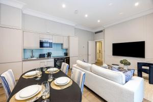 Una cocina y un comedor con mesa y sillas. en Buckingham & Lloyds Knightsbridge, en Londres