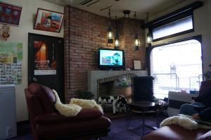 a living room with a fireplace and a tv at Hotel New Fukudaya in Minami Uonuma