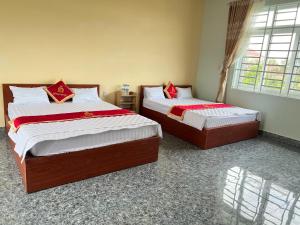 2 letti si trovano in una camera con finestra di Hồng Ngọc 2 Hotel Tà Đùng a Biđong Altre 21 foto