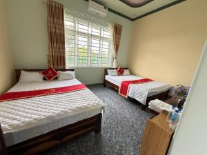 una camera da letto con due letti e una finestra di Hồng Ngọc 2 Hotel Tà Đùng a Biđong