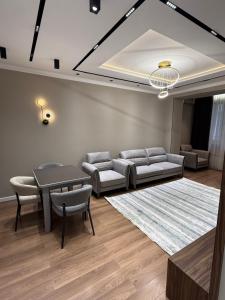 ドゥシャンベにあるApartment Bのソファとテーブルと椅子のあるリビングルーム
