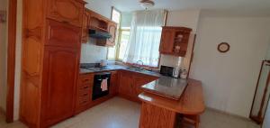 a kitchen with wooden cabinets and a stove top oven at Puerto Naos Beach 2 in Puerto Naos