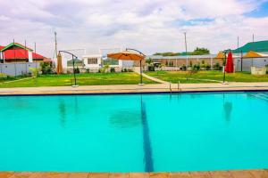 ein großer blauer Pool mit Sonnenschirmen und Gebäuden in der Unterkunft Ten villa luxury resort in Lodwar