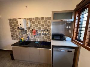 a kitchen with a sink and a stove at Arcade Serenity Suites in Chikmagalūr