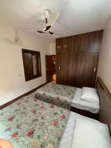 a small bedroom with two beds and a ceiling at Arcade Serenity Suites in Chikmagalūr