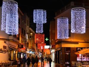 a group of lights hanging over a street at night at Parrot’s House in Lloret de Mar