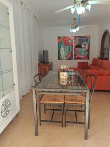 a dining room with a glass table and chairs at Bahia de Vera apartamento Abaco in Playas de Vera