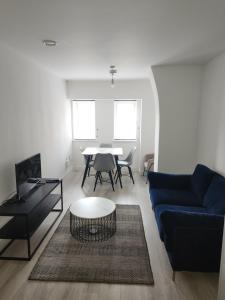 a living room with a blue couch and a table at Cosy flat near city centre in Longford