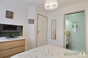 a bedroom with a bed and a tv and a bathroom at Maison six in Pléneuf-Val-André