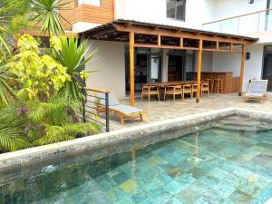 a pool in front of a house with a table and chairs at Villa Bliss in Trou aux Biches
