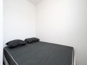 a bed in a white room with two pillows at La Dune 54 - Villa 3P6 in Valras-Plage