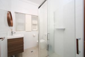 a bathroom with a shower and a toilet and a sink at Sydney, Bexley North holiday home 3bedrooms, free parking, close to Train station and CBD in Sydney +16 photos