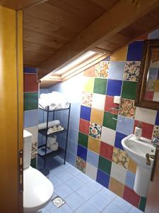 a bathroom with a toilet and a colorful tile wall at Αρχοντικό Κορκόντζελου in Nafpaktos