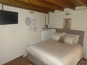 a bedroom with a bed and a flat screen tv at Αρχοντικό Κορκόντζελου in Nafpaktos