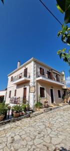 a large white building with balconies and potted plants at Αρχοντικό Κορκόντζελου in Nafpaktos