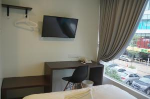 a bedroom with a desk and a tv on the wall at Hotel 57 USJ 21 Subang Jaya in Subang Jaya