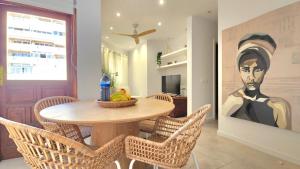 a dining room with a table and chairs and a painting at Aguaviva apartment in Callao Salvaje