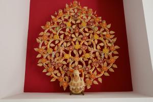 a painting of a gold mandala on a red wall at Casa Carmen in Alájar