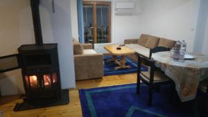 a living room with a fireplace and a couch at Holiday House Afan in Hadžići