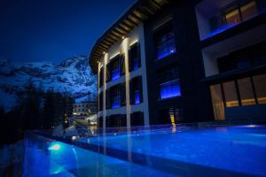 a building with a swimming pool at night at Hotel al Piolet in Breuil-Cervinia