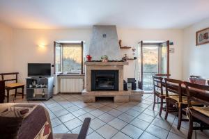 a living room with a fireplace and a tv at Casa Daniela in Druogno