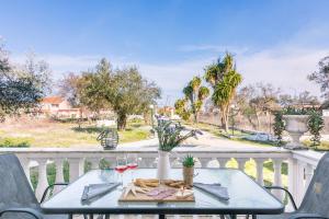 a table with a plate of food on a balcony at Lamda Apartments By Estia in Roda +7 photos