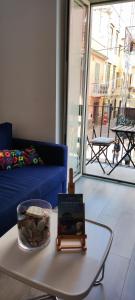a living room with a blue couch and a table at Casa AL CORSO Pozzuoli Centro in Pozzuoli