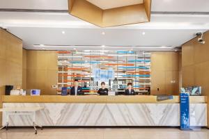 a lobby with three people sitting at a desk at Holiday Inn Express Zhangye by IHG in Zhangye