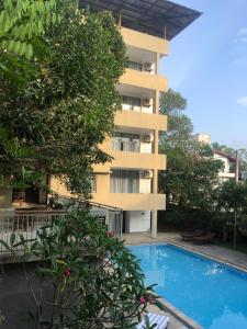 an apartment building with a swimming pool in front of it at Hotel Paradiso, in Unawatuna