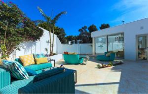 a patio with blue couches and chairs at Villa Italy in Playa d'en Bossa