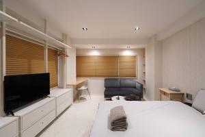 a bedroom with a bed and a flat screen tv at Real Life IIDABASHI in Tokyo