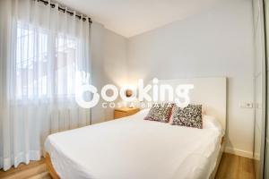 ein weißes Bett in einem Zimmer mit Fenster in der Unterkunft La Rambla in Sant Feliu de Guixols