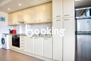 eine Küche mit weißen Schränken und einem Kühlschrank in der Unterkunft La Rambla in Sant Feliu de Guixols