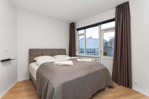 a bedroom with a bed and a large window at Spacious 3Bedroom Apartment on Rainbow Street in Reykjavík