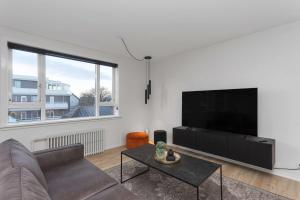 a living room with a couch and a flat screen tv at Spacious 3Bedroom Apartment on Rainbow Street in Reykjavík