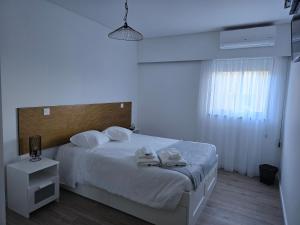 a bedroom with a bed with two towels on it at Salmoura's Place AL 4724 in Santa Cruz das Flores
