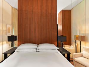 a bedroom with a large white bed and a couch at Le Metropolitan, Paris Tour Eiffel, a Tribute Portfolio Hotel in Paris