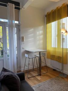 sala de estar con mesa y cortina amarilla en Studio design aux portes de Paris, en Gennevilliers 11 fotos más