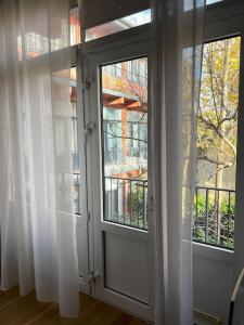 una puerta abierta a un balcón con cortinas blancas en Studio design aux portes de Paris, en Gennevilliers