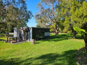 a tiny house in a field with a picnic table at Quiet Cabin in the forest-Pearcedale in Pearcedale