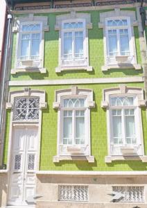 een gebouw van groene baksteen met witte ramen en deuren bij Duke`s Retreat in Porto