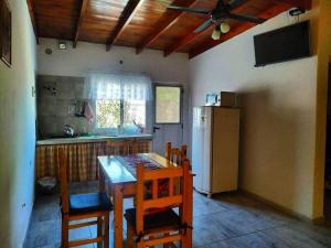 Una cocina con mesa y sillas y un refrigerador. en Angará Bungalows, en Federación
