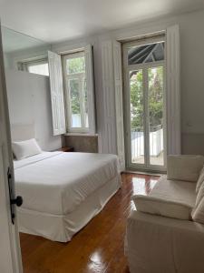 een witte slaapkamer met 2 bedden en een bank bij Duke`s Retreat in Porto +38 foto's