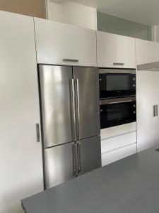 een keuken met een roestvrijstalen koelkast en een magnetron bij Duke`s Retreat in Porto